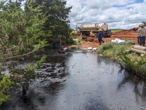 An Oil Skimmer hooked up to a vacuum truck to remove thick oil from a pond