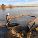 10" creek and swamp boom deployed with an oil drum skimmer to contain and clean up a thick oil spill