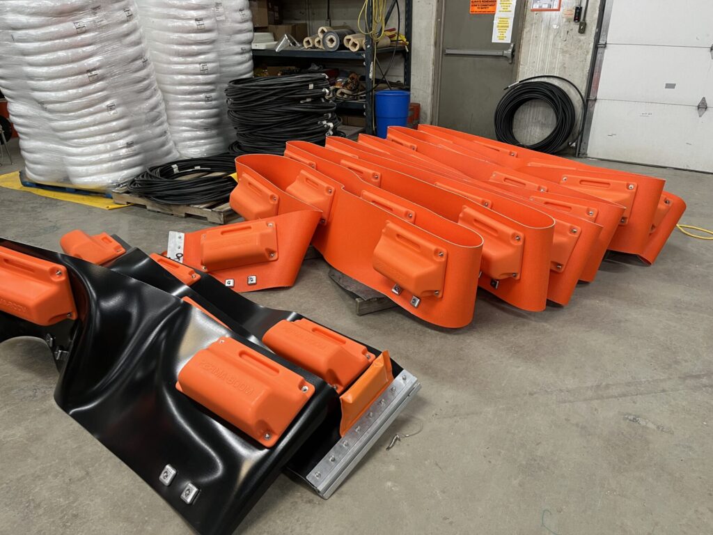 ACME's perma boom palleted and ready to ship. Black is PVC belting and orange is urethane belting
