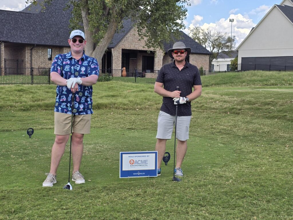 Two of ACME's employees in White Field's Golf Tournament at the hole that ACME sponsored