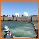 Perma Boom being deployed near a pier in a marina