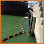 Perma Boom deployed near a ship at a docking station