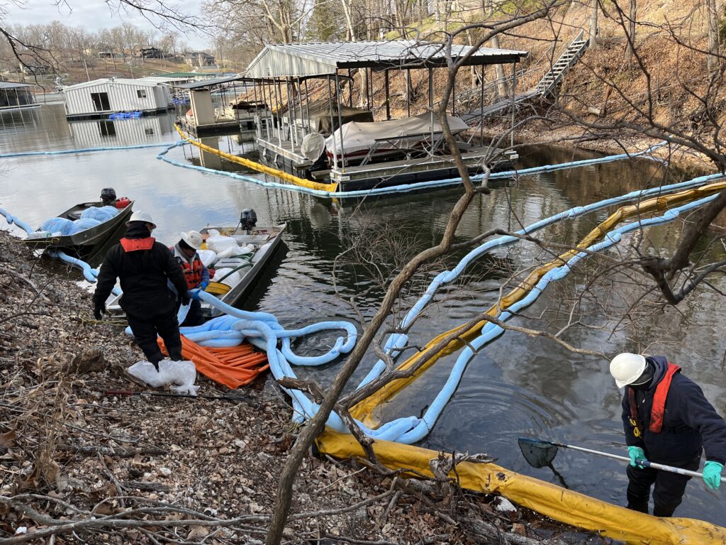 ACME employees deploying containment boom and sorbent boom around boat docks in February