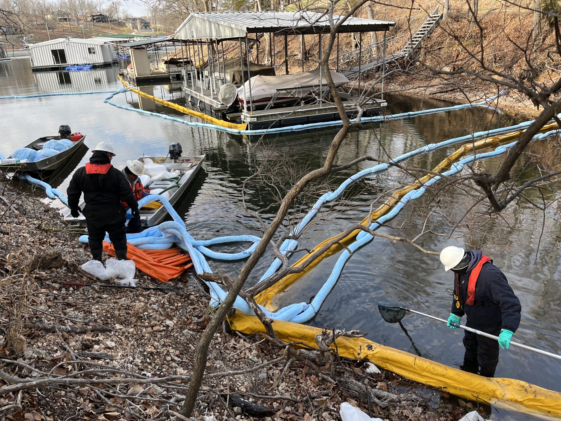 ACME Environmental spill technicians cleaning diesel oil spill near a dock and cove 
