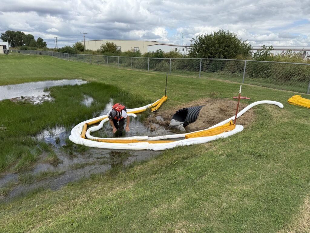 Oil containment boom and sorbent boom deployed around initial spill area