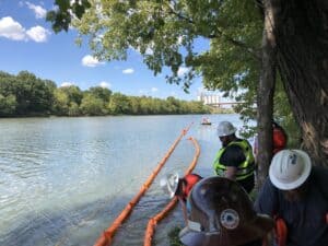 Students of the Boom School deploying containment boom on the river at mobile booming site