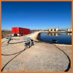 Oil drum skimmer connected to a pump thats pumping recovered oil into a frac tank